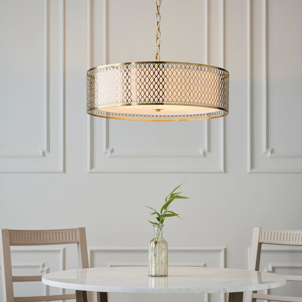 round gold pendant light over a dining table in a luxury living room