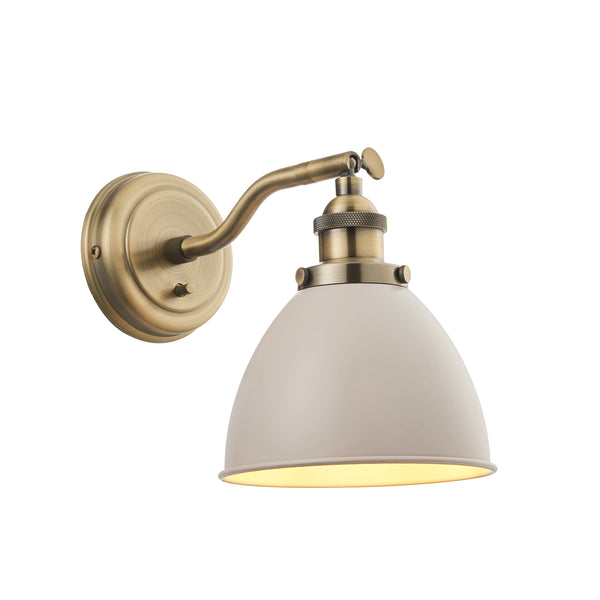 Brushed gold coloured round back plated and a simply metal taupe shade. Wall light on a white background for contrast