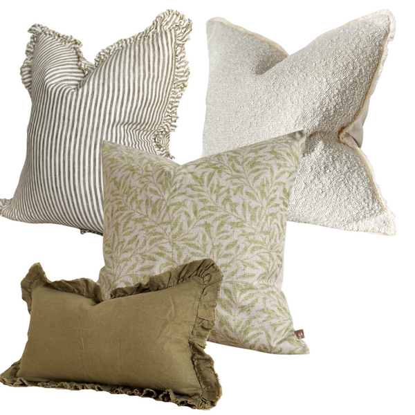 Set of 4 Olive green and cream cushions 1 square linen ruffled edge cream cushion with vertical all over chunky olive stripes. 1square cream boucle cushion. 1 square cotton beige cushion with an intricate olive leaf print. 1 rectangle linen cushion with a ruffled edge. All stuffed with our duck feathered filled pads. Sat on a plain white background.